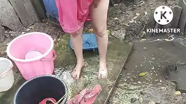 Indian house wife bathing outside