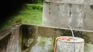 Indian village girl bathing near water tank outdoor